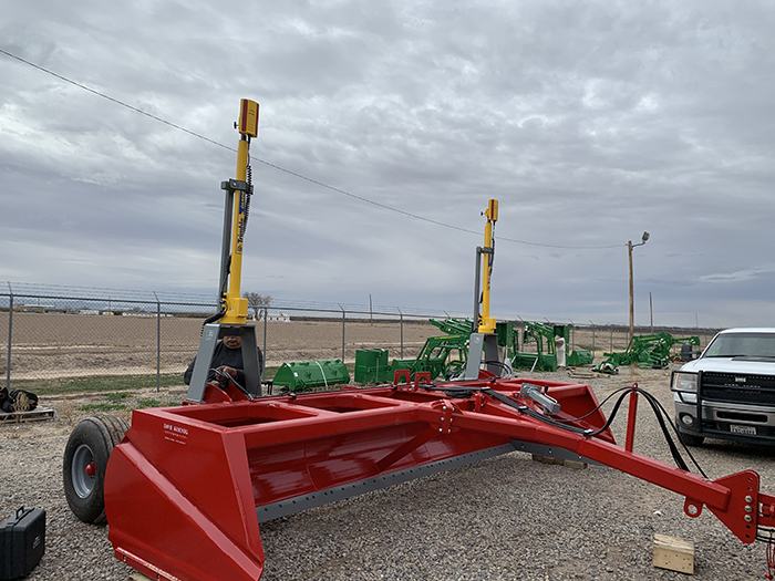 Calibrated rental laser level set up on a tripod in a field